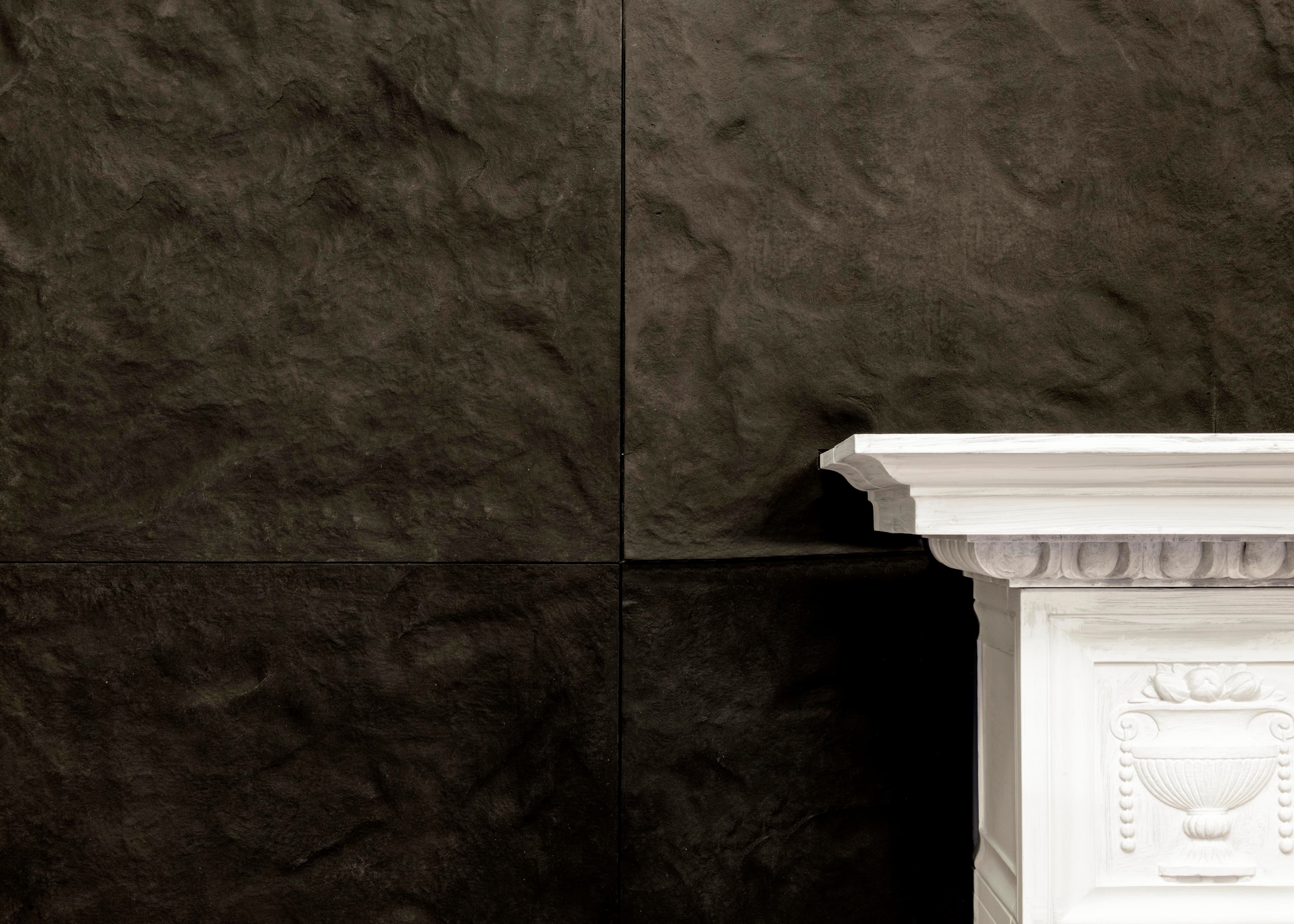 Black slate wall with white carved marble fireplace